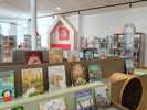 Foto der neugestalteten Kinderbuchabteilung. Im Vordergrund ist das neue Kletter- und Ausstellmöbel mit vielen Büchern zu sehen, im Hintergrund die neue Hütte mit Sitzgelegenheiten und weitere Regale.
