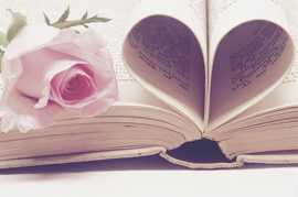 Ein aufgeschlagenes Buch mit der Rose, zwei Seiten sind zu einem Herz zusammengelegt