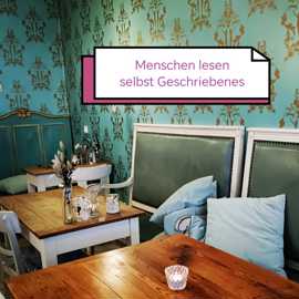 Das Bild zeigt eine Sitzecke in einem kleinen Cafe. Darüber steht: Menschen lesen selbst Geschriebenes
