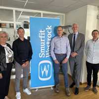 Fünf Personen stehen vor einem Rollup der Firma Smurfit Westrock.