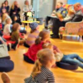 Kinder, die jemandem beim Vorlesen zuhören